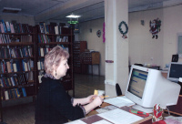 На фото: Тертычная С.А. за кафедрой выдачи литературы в момент регистрации нового читателя в программе LiberMedia. Декабрь 2009 г.